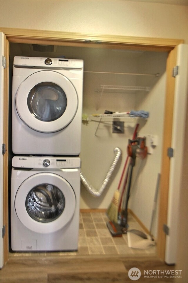 washroom with laundry area, wood finished floors, and stacked washer and dryer