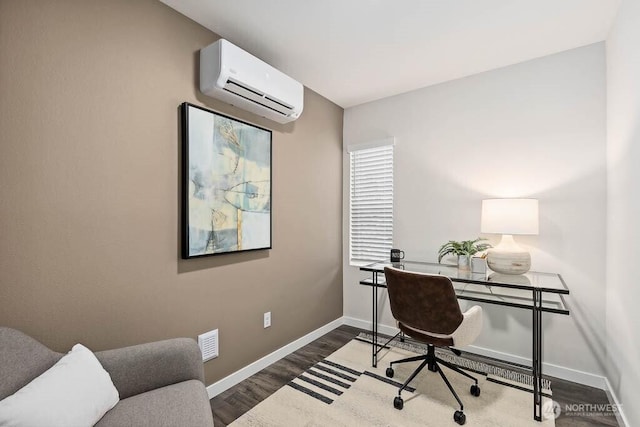 office featuring visible vents, baseboards, wood finished floors, and a wall mounted AC