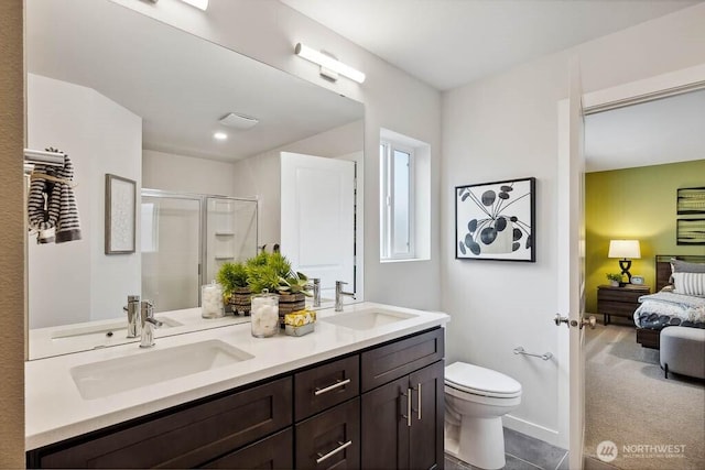 ensuite bathroom featuring a shower stall, toilet, connected bathroom, and a sink