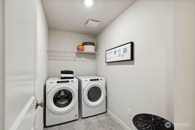 laundry area with baseboards, washing machine and dryer, and laundry area