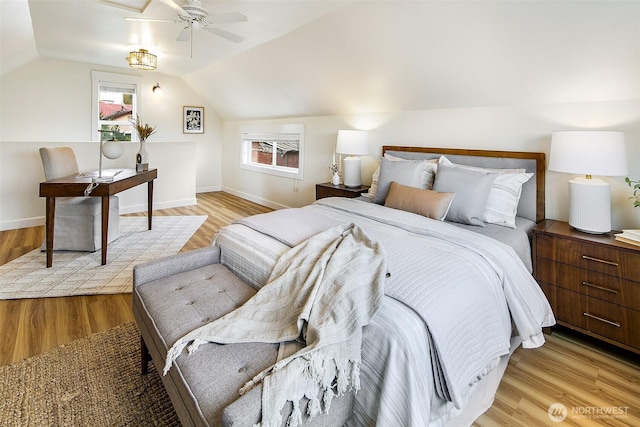 bedroom with light wood finished floors, baseboards, and lofted ceiling