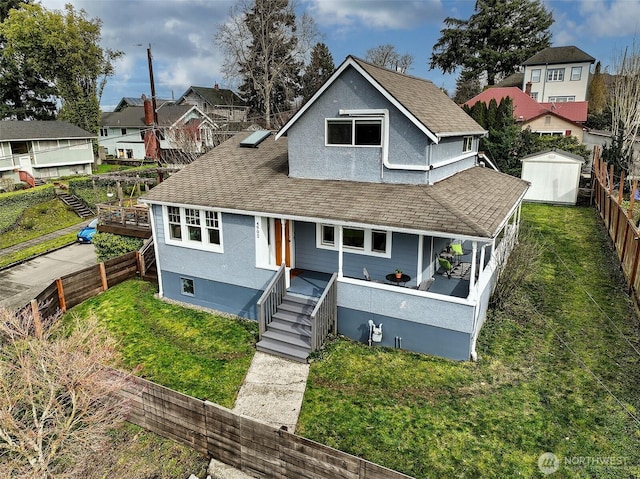 view of front of house with a front lawn, a fenced backyard, and a shingled roof