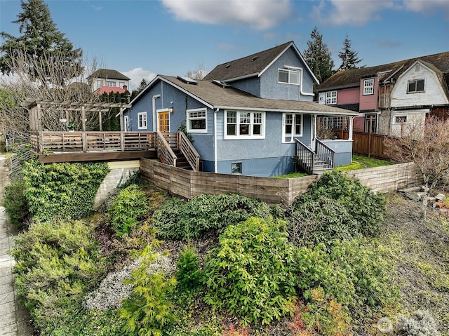 back of property featuring stairs, a wooden deck, fence, and stucco siding