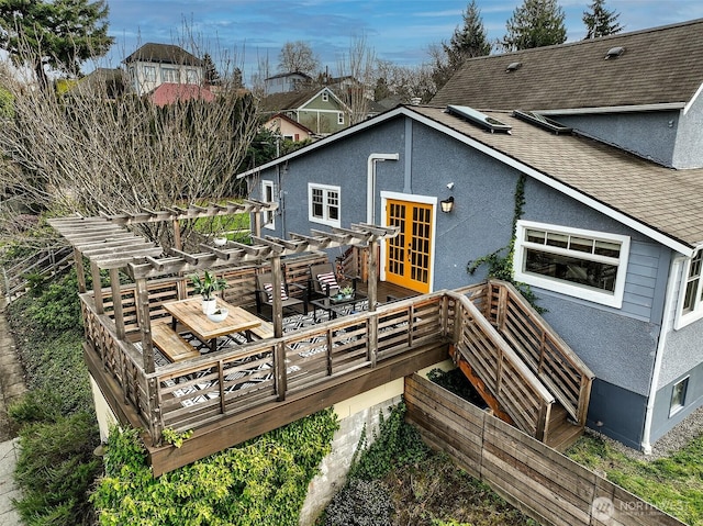 back of house featuring french doors, roof with shingles, a deck, and stucco siding