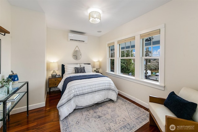 bedroom featuring an AC wall unit, wood finished floors, and baseboards