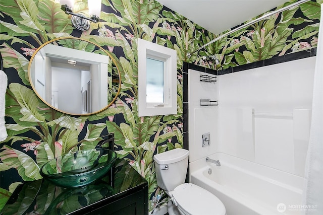 bathroom with shower / bathtub combination, toilet, vanity, and wallpapered walls