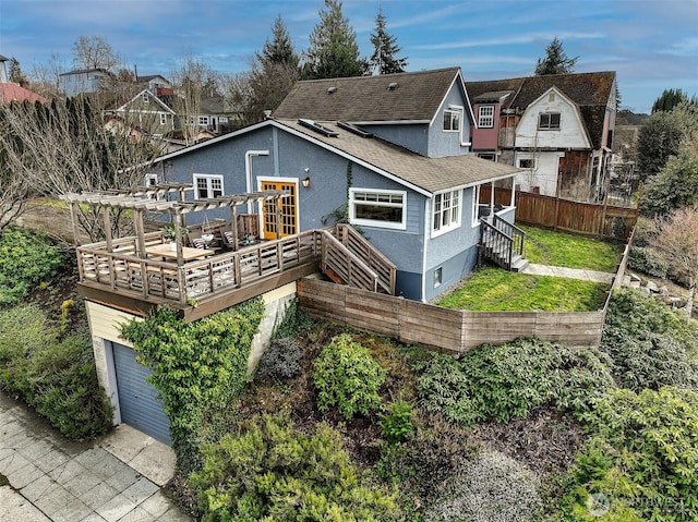 rear view of house with fence, roof with shingles, a wooden deck, a pergola, and stucco siding