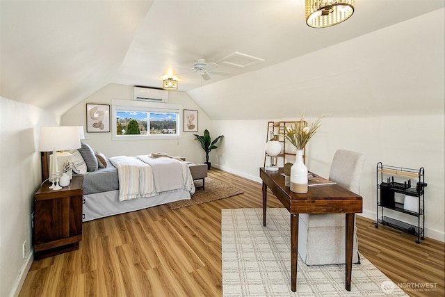 bedroom with vaulted ceiling, baseboards, light wood finished floors, and a wall mounted AC