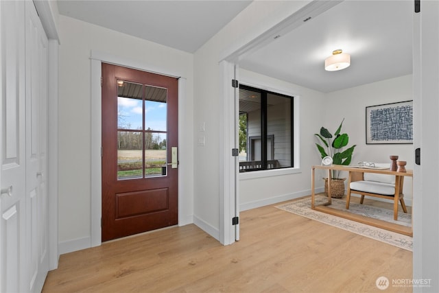 foyer entrance featuring light wood-type flooring and baseboards