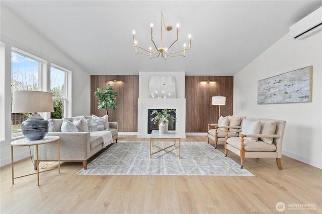 living room with a wall unit AC, wooden walls, a notable chandelier, and wood finished floors