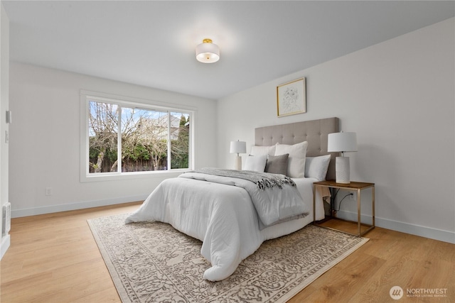 bedroom with baseboards and light wood finished floors