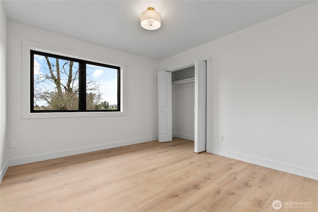 unfurnished bedroom with baseboards and light wood-style floors