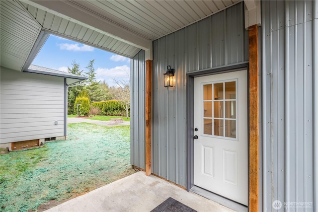 entrance to property featuring a yard and board and batten siding