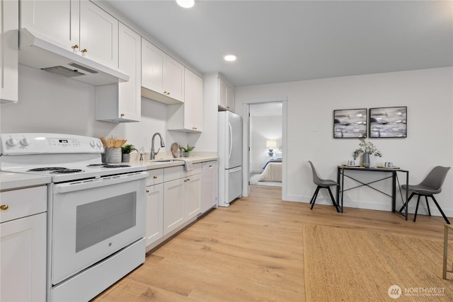 kitchen featuring under cabinet range hood, light countertops, white appliances, white cabinetry, and a sink