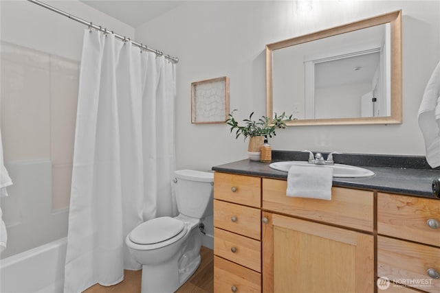 bathroom with shower / bath combo with shower curtain, toilet, and vanity