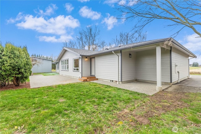 rear view of property featuring a lawn and a patio area