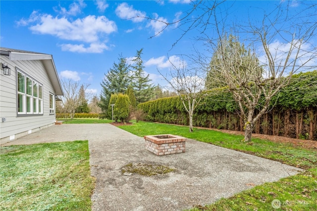 view of yard featuring a patio and an outdoor fire pit