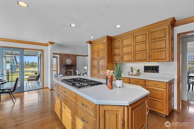 kitchen with stainless steel gas stovetop, a healthy amount of sunlight, a fireplace, and light countertops