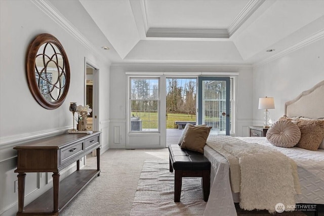 carpeted bedroom with a wainscoted wall, ornamental molding, access to outside, a decorative wall, and a raised ceiling