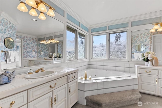 full bathroom with vanity, a tub with jets, crown molding, and wallpapered walls