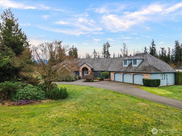 view of front of home with driveway, an attached garage, and a front yard