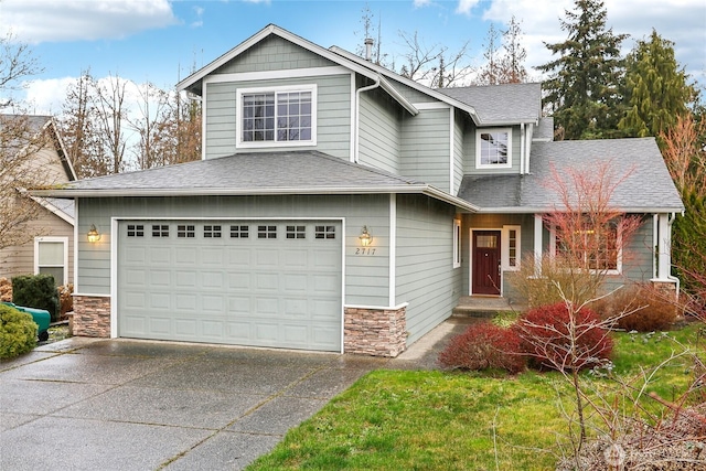 view of front of property with stone siding, driveway, a shingled roof, and an attached garage