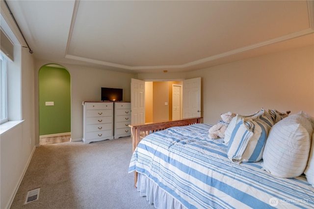 bedroom featuring arched walkways, visible vents, baseboards, and carpet