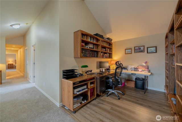 office area with high vaulted ceiling, light wood-type flooring, and baseboards