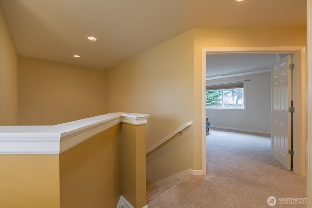 hall with recessed lighting, baseboards, an upstairs landing, and light carpet