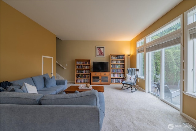 carpeted living room featuring visible vents, baseboards, and stairs