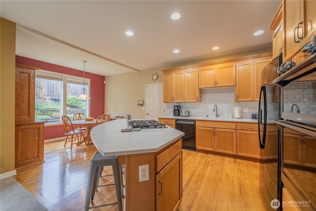 kitchen featuring dishwasher, light wood-type flooring, tasteful backsplash, and a center island