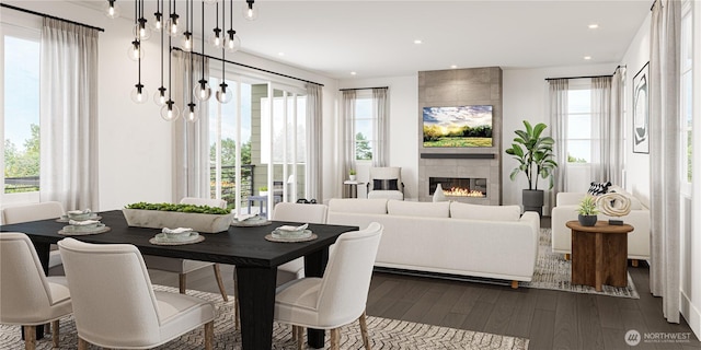 dining space with dark wood finished floors, a tiled fireplace, and recessed lighting