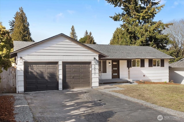 single story home featuring aphalt driveway, a garage, and a shingled roof