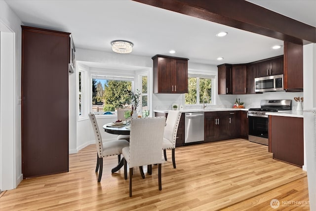 kitchen with light wood-type flooring, recessed lighting, dark brown cabinetry, appliances with stainless steel finishes, and light countertops