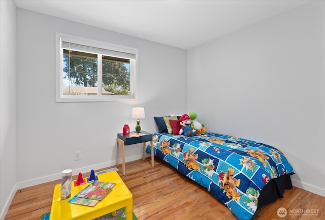bedroom with wood finished floors and baseboards