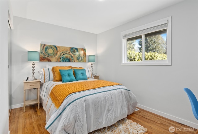bedroom featuring wood finished floors and baseboards