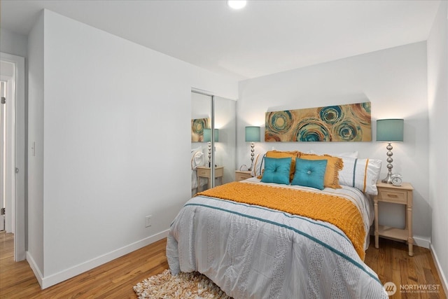 bedroom featuring wood finished floors, a closet, and baseboards