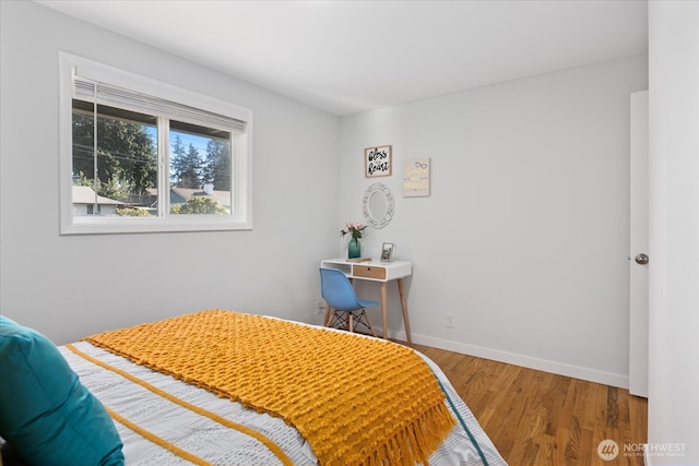bedroom with wood finished floors and baseboards