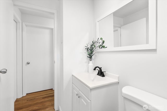 bathroom featuring vanity, toilet, and wood finished floors