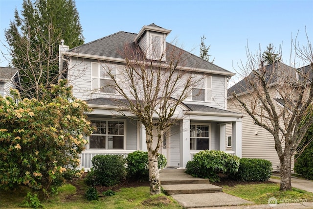 american foursquare style home with covered porch and roof with shingles