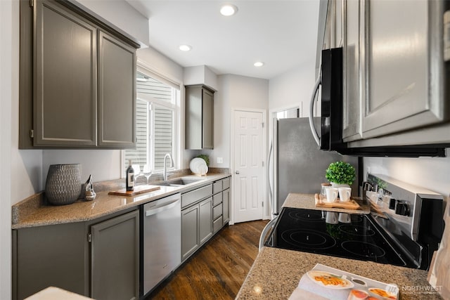 kitchen with stainless steel dishwasher, gray cabinetry, a sink, and electric range oven