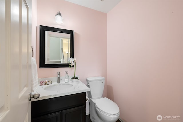 half bathroom featuring toilet and vanity