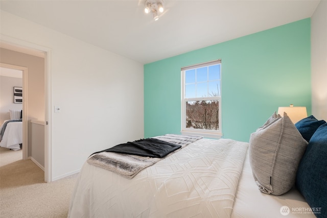 bedroom with baseboards and light colored carpet