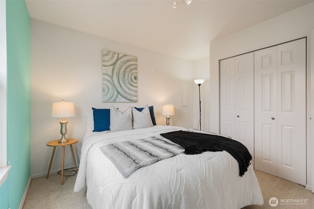 carpeted bedroom featuring a closet and baseboards