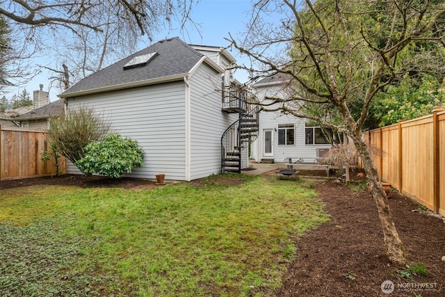 exterior space featuring a lawn, stairs, a fenced backyard, and roof with shingles