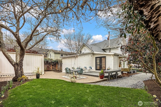 back of house with a lawn, a patio, fence, french doors, and an outdoor structure