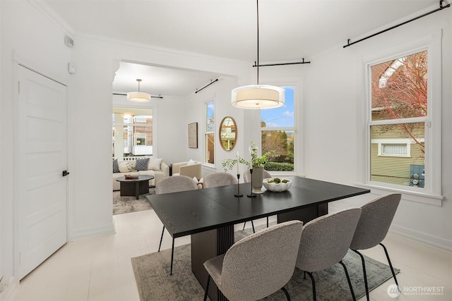 dining area with crown molding and baseboards