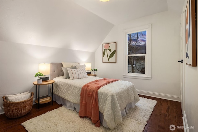 bedroom featuring vaulted ceiling, wood finished floors, and baseboards