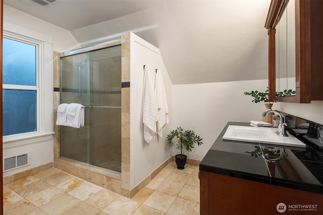 full bath featuring visible vents, baseboards, a stall shower, and vaulted ceiling