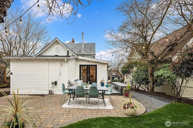 rear view of house with a patio area, french doors, and fence